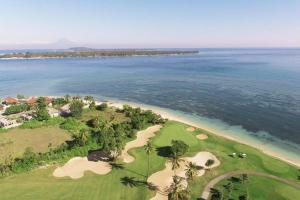 an aerial view of a golf course and the ocean at Villa Semoga in Tanjung