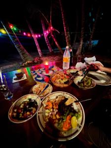 a table with many plates of food on it at Sun & Sea 365 in Balapitiya