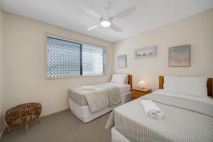 a bedroom with two beds and a window at Seacrest Unit 2 Moffat Beach QLD in Caloundra
