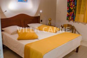 two beds in a room with yellow pillows at Residence Can' Hibiscus in Le Marin +18 photos
