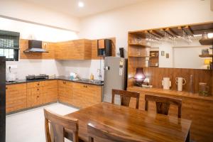 a kitchen with a table and a refrigerator at Luho Aarambha in Bangalore