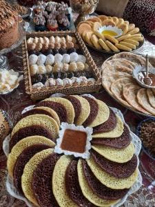 a table with many different types of cakes and pastries at Ferme agafay in El Karia
