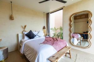 a bedroom with a large bed and a mirror at Nema Uluwatu in Uluwatu
