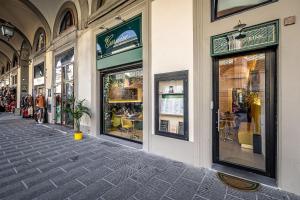 a building with windows with tables and chairs on a street at B&B Lorenzo de' Medici in Florence