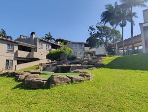 a rock garden in front of a building at Cosy Beach Cottage 52 Chaka's Rock Chalets Resort in Ballito