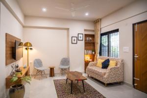 a living room with a couch and a table at Luho Aarambha in Bangalore