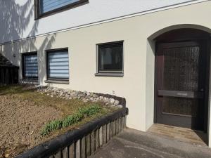 a house with a wooden door and a fence at Ferienwohnung LuMa in Rottenacker in Rottenacker