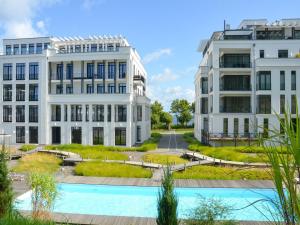 two buildings with a pool in front of them at Villa Philine - Meerblicksuite "Carlotta" in Ostseebad Sellin