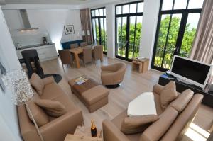 a living room with a couch and a television at Villa Philine - Meerblicksuite "Carlotta" in Ostseebad Sellin +21 photos