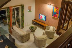 a living room with wicker chairs and a television at Residence Can' Hibiscus in Le Marin