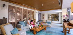 a woman and two children sitting in a living room at Resorts World Langkawi in Pantai Cenang +68 photos