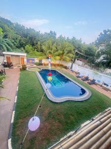 a swimming pool with an umbrella in a yard at Bamboo in Kuilapayam