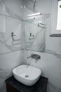 a bathroom with a sink and a glass shower at Rudra Homestay - Rishikesh in Rishīkesh