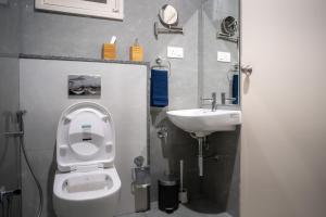 a bathroom with a toilet and a sink at Luho Aarambha in Bangalore +43 photos