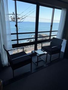 a living room with a view of the ocean at HOTEL&RESORT Izu no Ne in Higashiizu