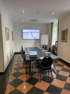 a conference room with a table and chairs and a screen at Hotel Am Mühlenteich in Schwelm