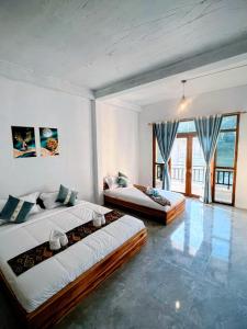 a bedroom with two beds and a large window at Views Backpackers Hostel in Nongkhiaw