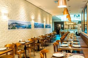 a restaurant with wooden tables and chairs and a brick wall at Rede Andrade Lapa in Rio de Janeiro