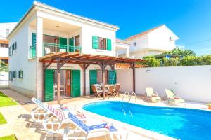 a villa with a swimming pool and a house at Villa Cvita 80 m from the sea, free breakfast - DIRECT LANDLORD in Hvar