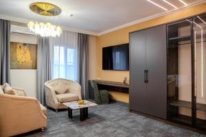 a living room with a couch a chair and a table at Infinity Plaza Hotel Block 2 in Atyrau