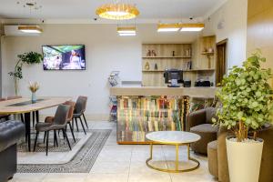 a waiting room with a table and chairs at Infinity Plaza Hotel Block 2 in Atyrau