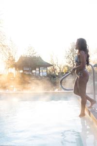a woman standing in a pool with a hose at De Bronsbergen Boutique Wellness & Hotel in Zutphen