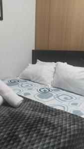 a bed with two pillows and a blanket on it at Nygel Staycation at Shell Residences in Sampong