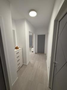 an empty white room with a dresser and a hallway at White House in Ploieşti