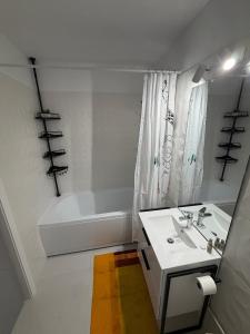 a white bathroom with a sink and a bath tub at White House in Ploieşti