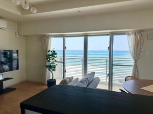 a living room with a view of the ocean at アラハブルーリゾート in Chatan