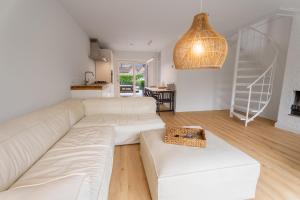 a living room with a white couch and a staircase at Spaanse Galeien 13 in Retranchement