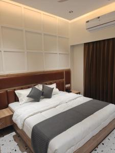 a bedroom with a large bed with pillows at Hotel Natraj Sirsa in Sirsa