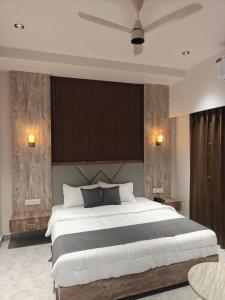 a bedroom with a large bed with a ceiling at Hotel Natraj Sirsa in Sirsa