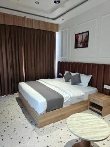 a bedroom with a large bed and a table at Hotel Natraj Sirsa in Sirsa