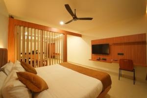 a bedroom with a bed with a ceiling fan at Arunaragha in Mysore