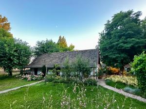 an old house with a garden in front of it at PusztaFarm - Boutique Retreat with Wellness 6 to 8 Guests in Fülöpháza