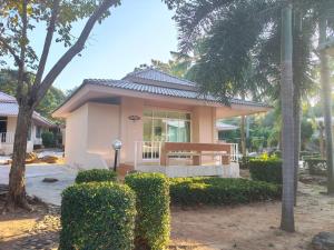 a small house with a bench in front of it at ขวัญใจปราณ รีสอร์ท in Ban Pak Nam Pran