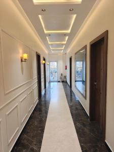 a hallway with a long corridor with white walls and a ceiling at Hotel Natraj Sirsa in Sirsa