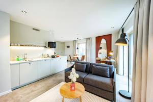 a living room and kitchen with a couch and a table at Brera Meckenbeuren-Friedrichshafen in Meckenbeuren