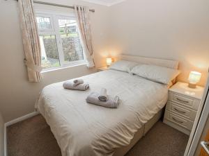 a bedroom with a bed with towels on it at Dono's Lodge in Narberth