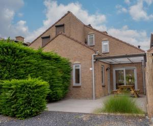 a brick house with an open garage with a picnic table at Spaanse Galeien 13 in Retranchement