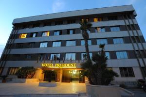 un bâtiment devant lequel se trouve un panneau d'enregistrement d'hôtel dans l'établissement Hotel President, à Marsala