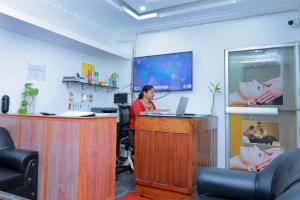 a man sitting at a desk in an office with a laptop at Sun Shine Resort & Spa in Kovalam