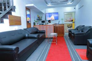 a living room with black leather couches and a tv at Sun Shine Resort & Spa in Kovalam