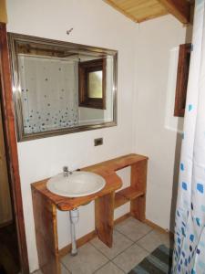 bagno con lavandino e specchio di Cabaña Pucon a Huife a Pichare