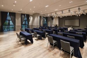 a conference room with tables and chairs and a screen at Chestertons Sokcho in Sokcho +52 photos