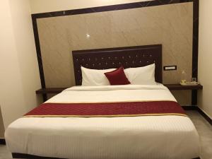 a bedroom with a large bed with a red pillow at Tamil Homestay in Thanjāvūr