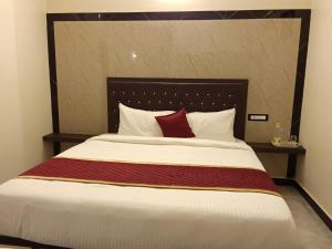 a bedroom with a large bed with a red pillow at Tamil Homestay in Thanjāvūr