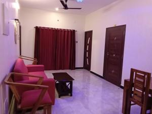 a living room with purple chairs and a table at Tamil Homestay in Thanjāvūr