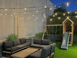 a patio with a couch and a playground with a swing at Brit Hotel Essentiel Reims Taissy in Reims